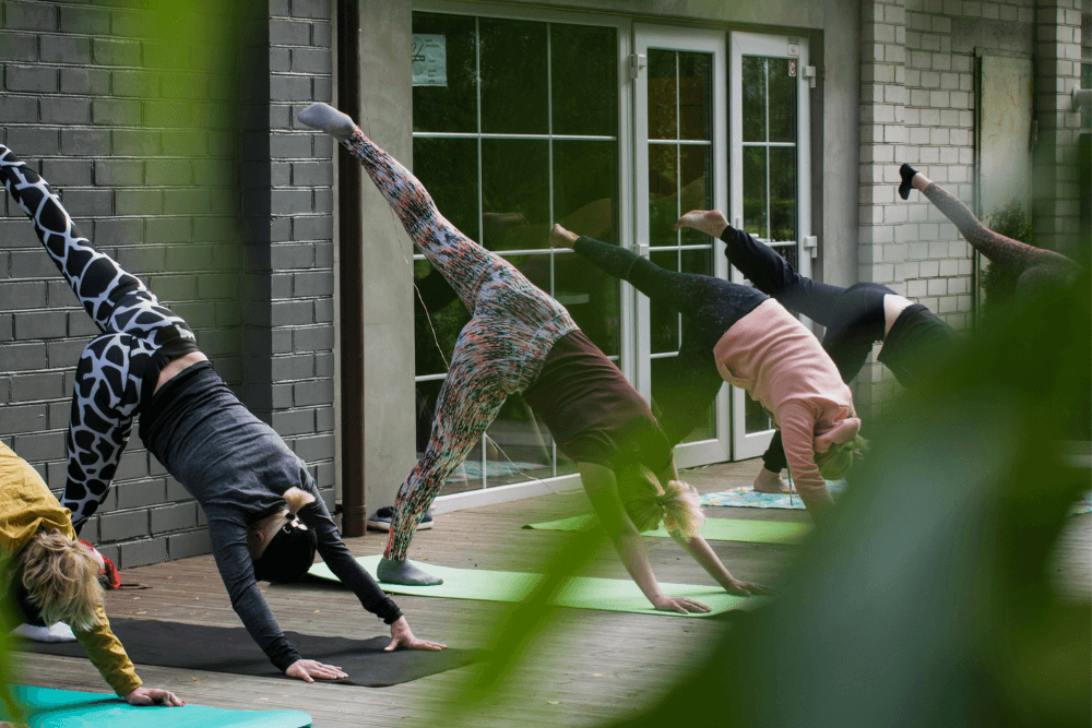 קבוצת נשים בתרגול יוגה בחוץ – איזון, בריאות ואורח חיים טבעי