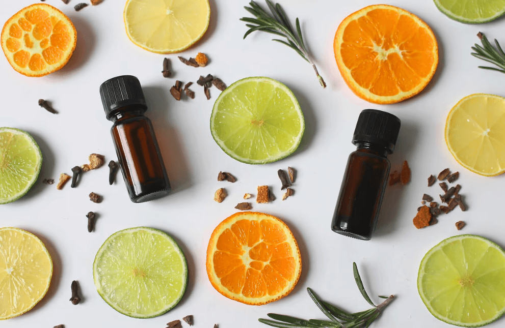 בקבוקי שמנים אתרים לצד פרוסות פירות הדר, רוזמרין ותבלינים