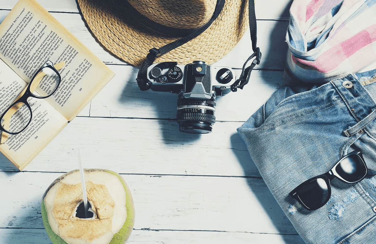 מוצרים לטיול מצלמה, ספר, משקפי שמש וכוסע